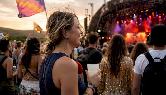 Concertgoer wearing earplugs in festival crowd